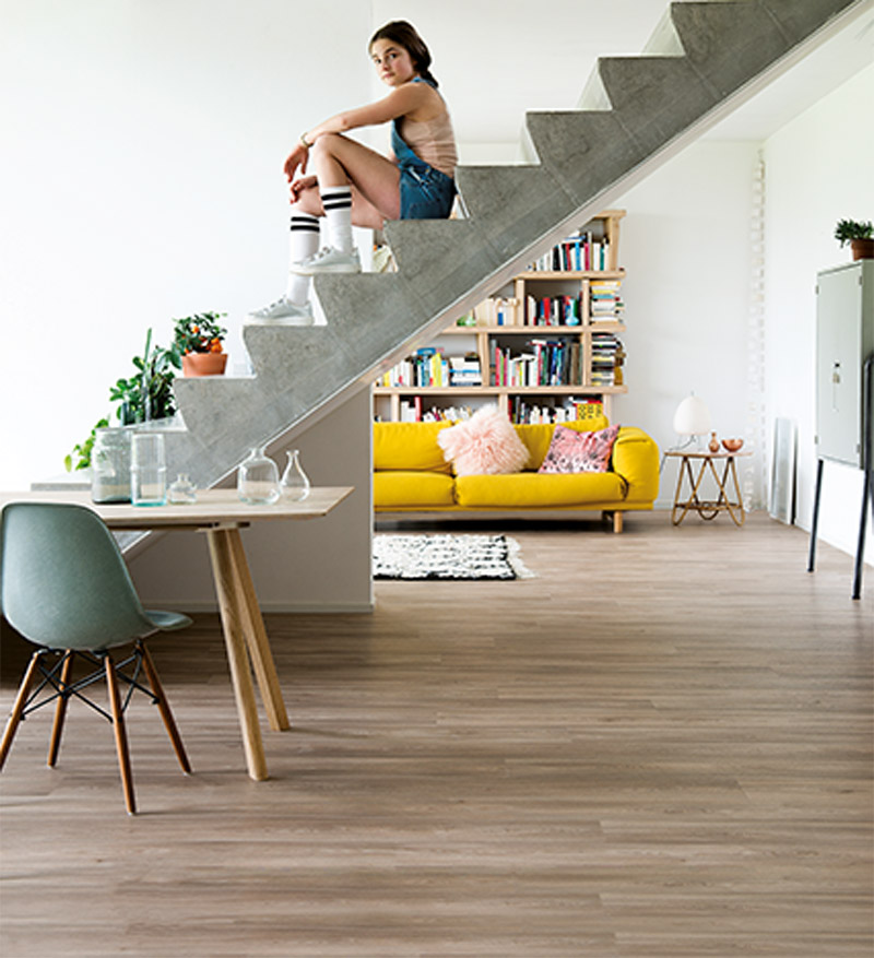 Meisje op trap op een vinylvloer wat is het verschil tussen vinyl en laminaat